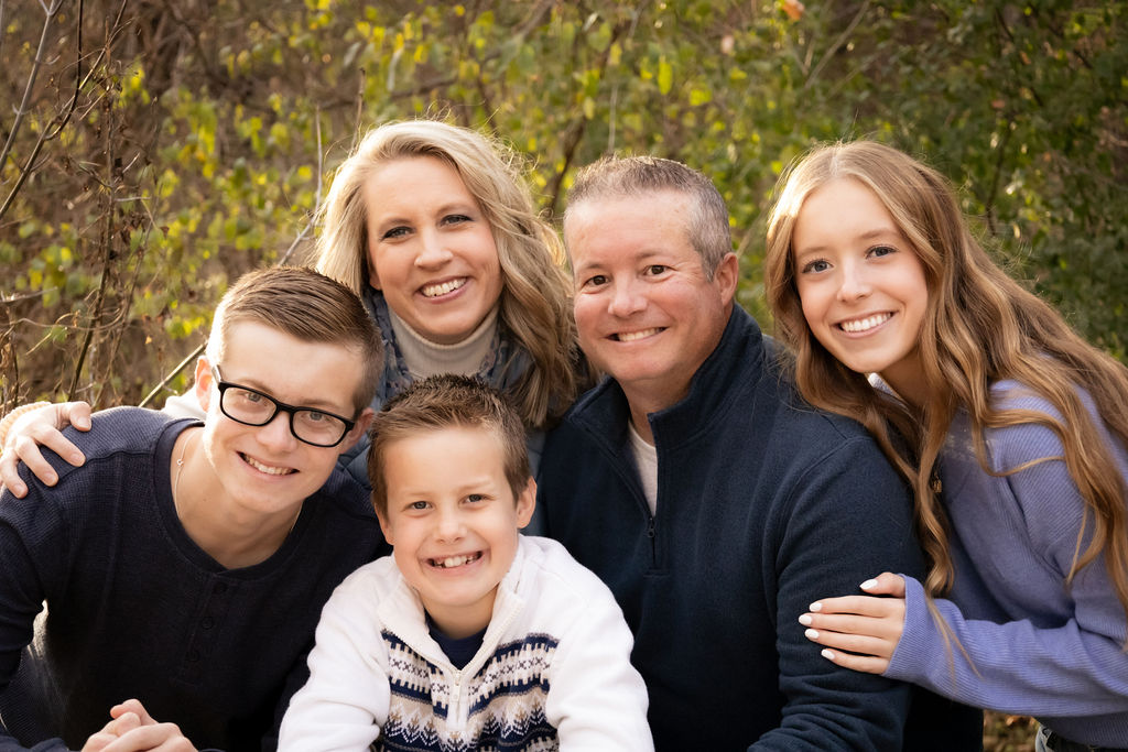 Outdoor family portrait of Adrienne McKeown, husband, and their three children.