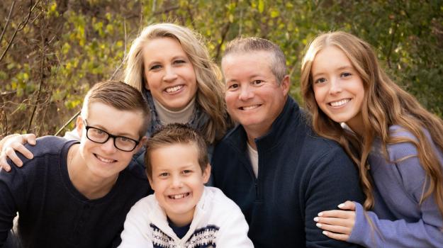 Outdoor family portrait of Adrienne McKeown, her husband, and their three children.