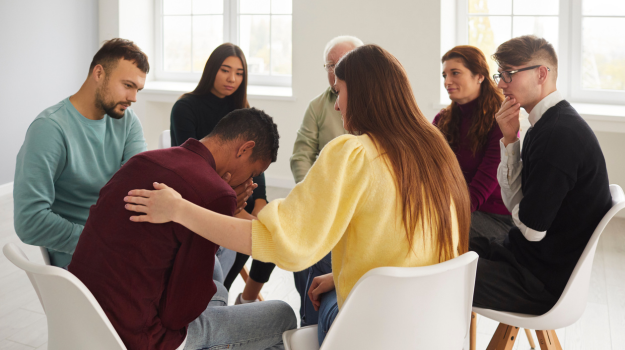 Seven diverse individuals supporting one another in a grief support group.